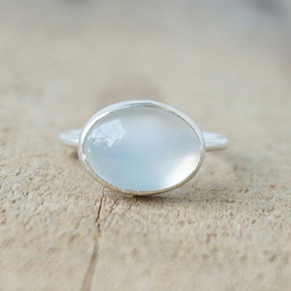 silver ring with a translucent stone on a wooden background