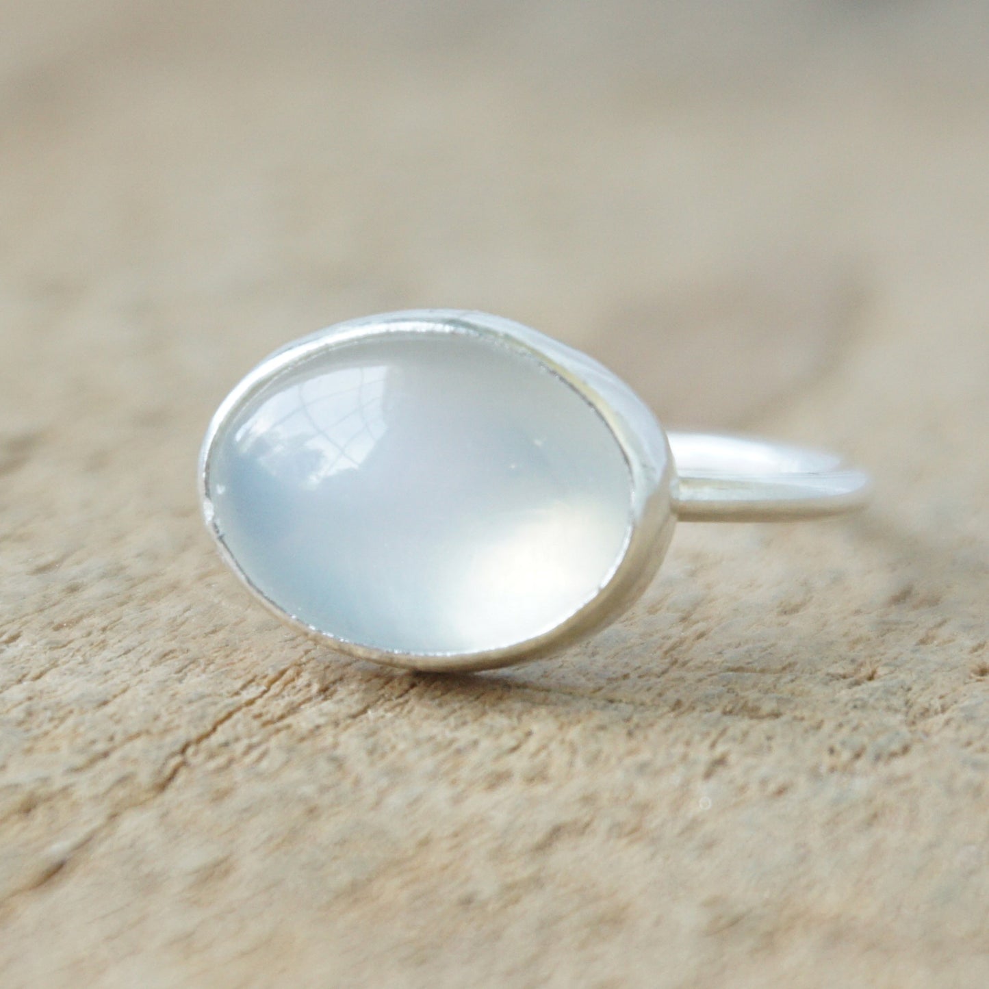 silver ring with a translucent stone on a wooden background