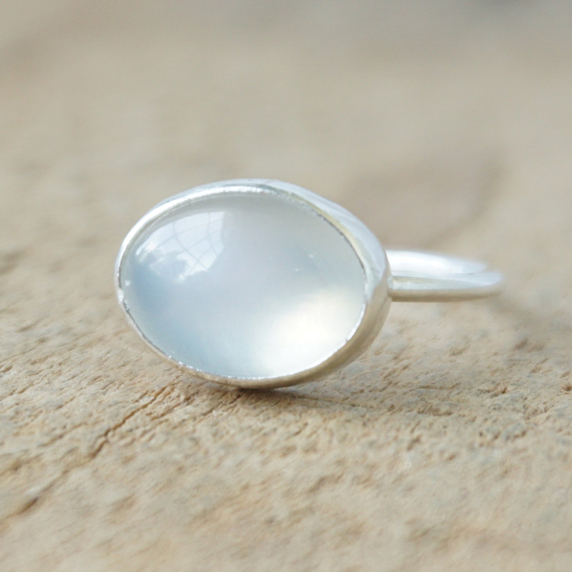 silver ring with a translucent stone on a wooden background