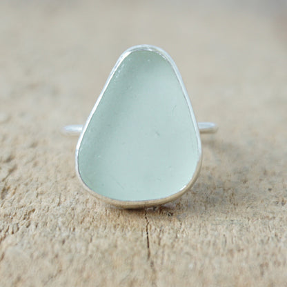 silver ring with seafoam green sea glass on a wooden background