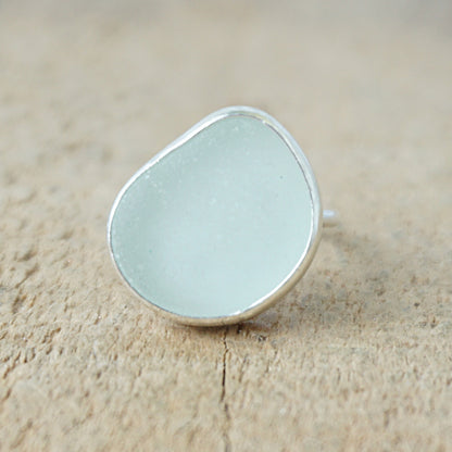 silver ring with seafoam green sea glass on a wooden background