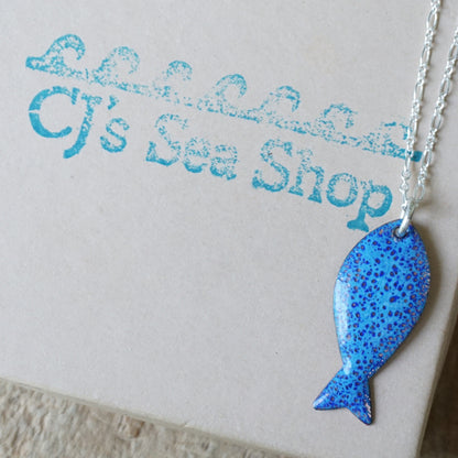 Blue fish-shaped pendant on a gift box