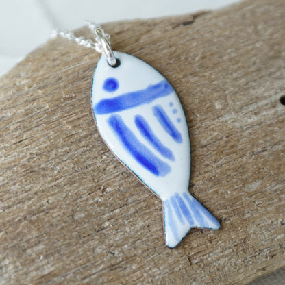 Fish-shaped pendant with blue design on a white background