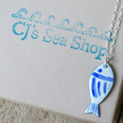 Fish-shaped pendant necklace on a gift box