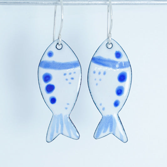 Fish-shaped earrings with blue accents on a white background