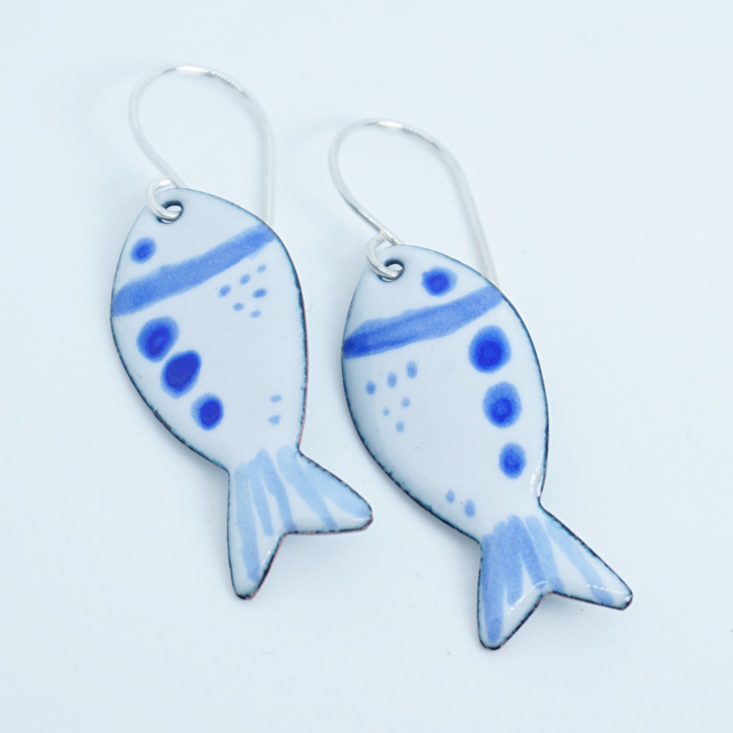 Fish-shaped earrings with blue and white design on a white background