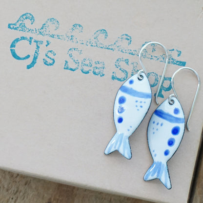 Fish-shaped earrings with blue accents on a gift box