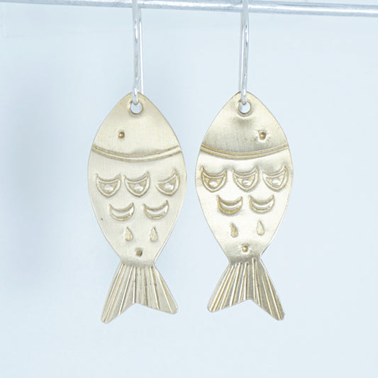 Gold fish-shaped earrings on a white background