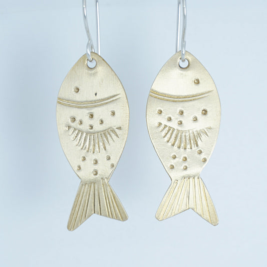 Gold fish-shaped earrings on a white background
